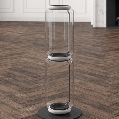 Clear cylindrical object with black base on a wooden floor