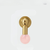 Brass knob with glossy pink gemstone sphere handle photographed on a white background.