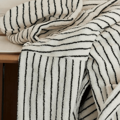 Black and white striped towel draped over a wooden surface