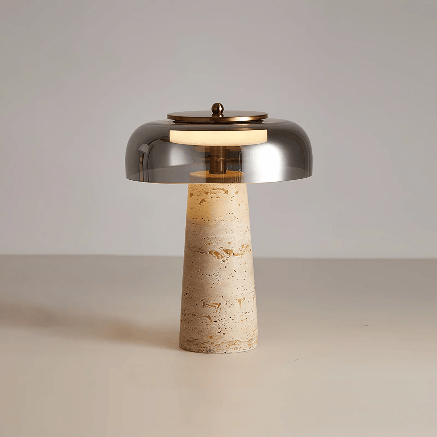 Table lamp with metallic shade and textured base on a neutral background