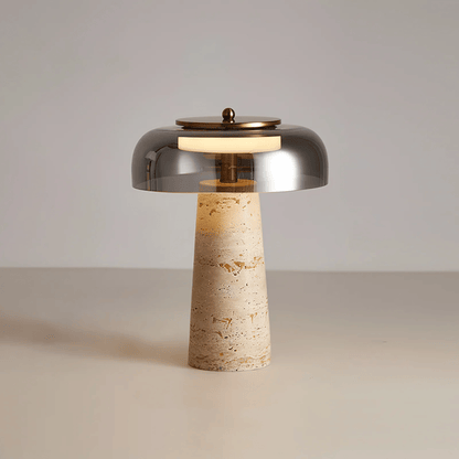 Table lamp with metallic shade and textured base on a neutral background