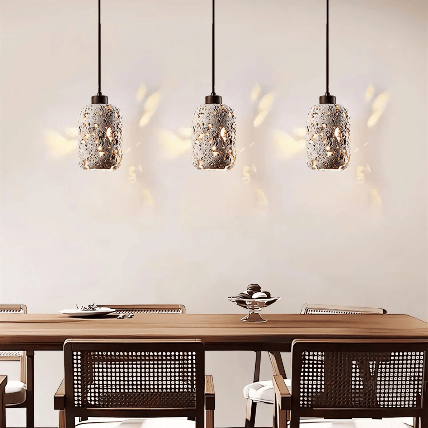 Three pendant lights hanging above a dining table with chairs.