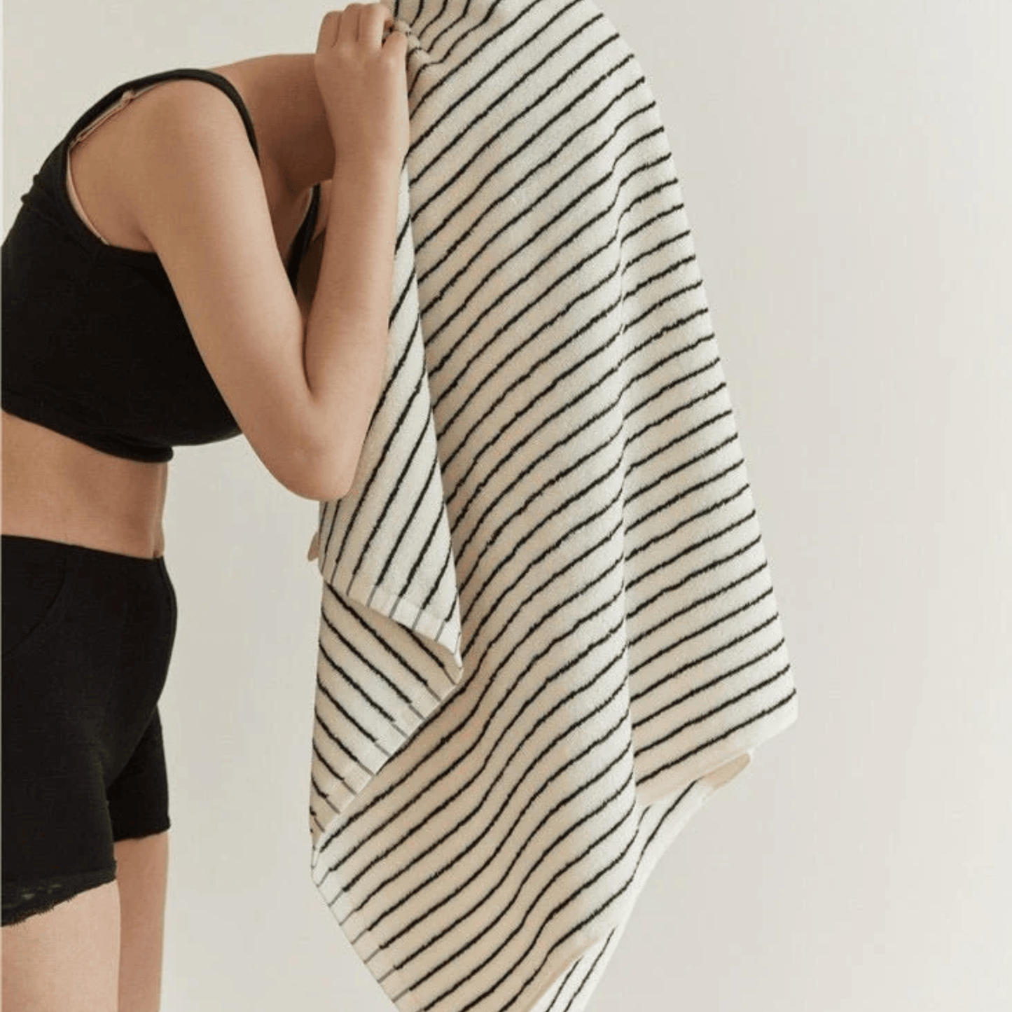 Someone drying her hair with a Striped Black & White Towel