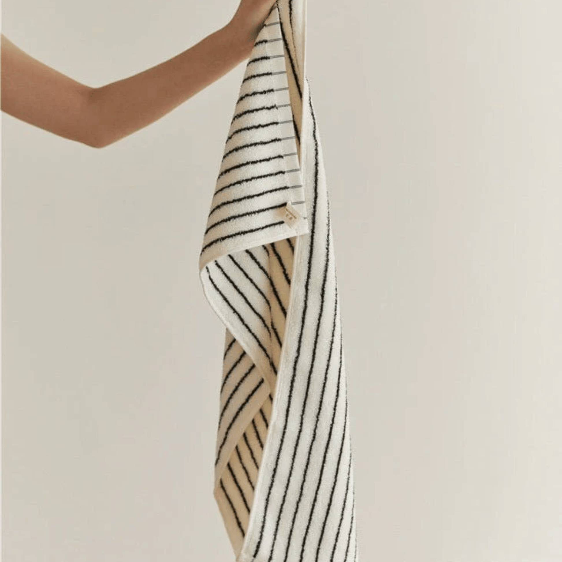 Someone holding a Striped Black & White Face Towel