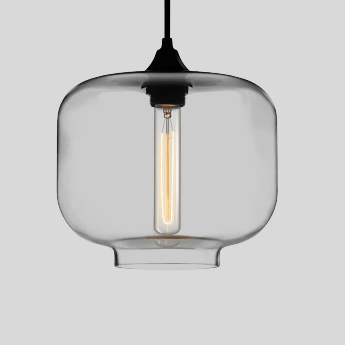 Clear glass pendant light with a visible bulb on a gray background