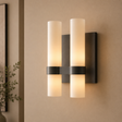 Wall-mounted light fixture with two cylindrical lights on a beige wall.