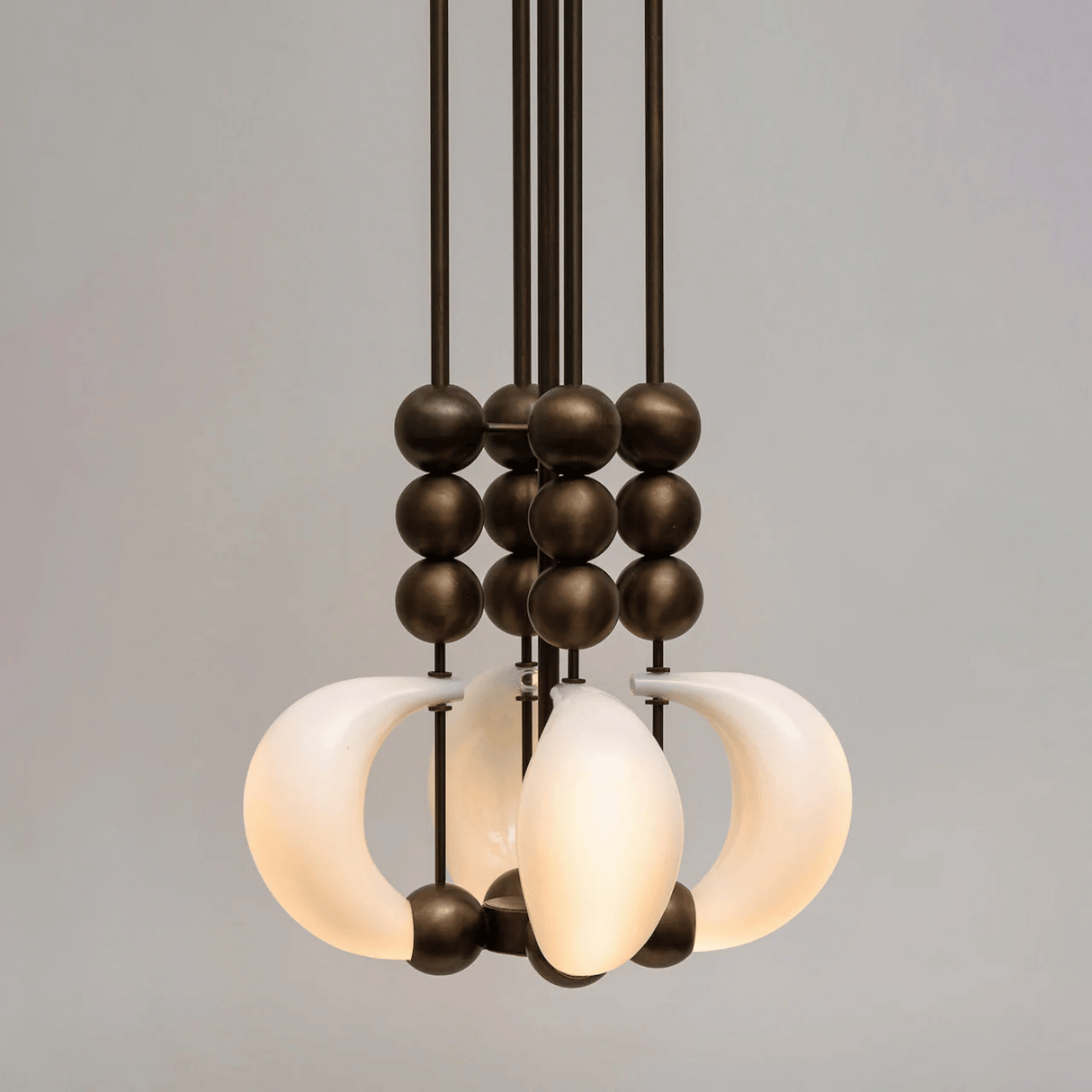 Modern chandelier with glass shades and metal accents on a gray background