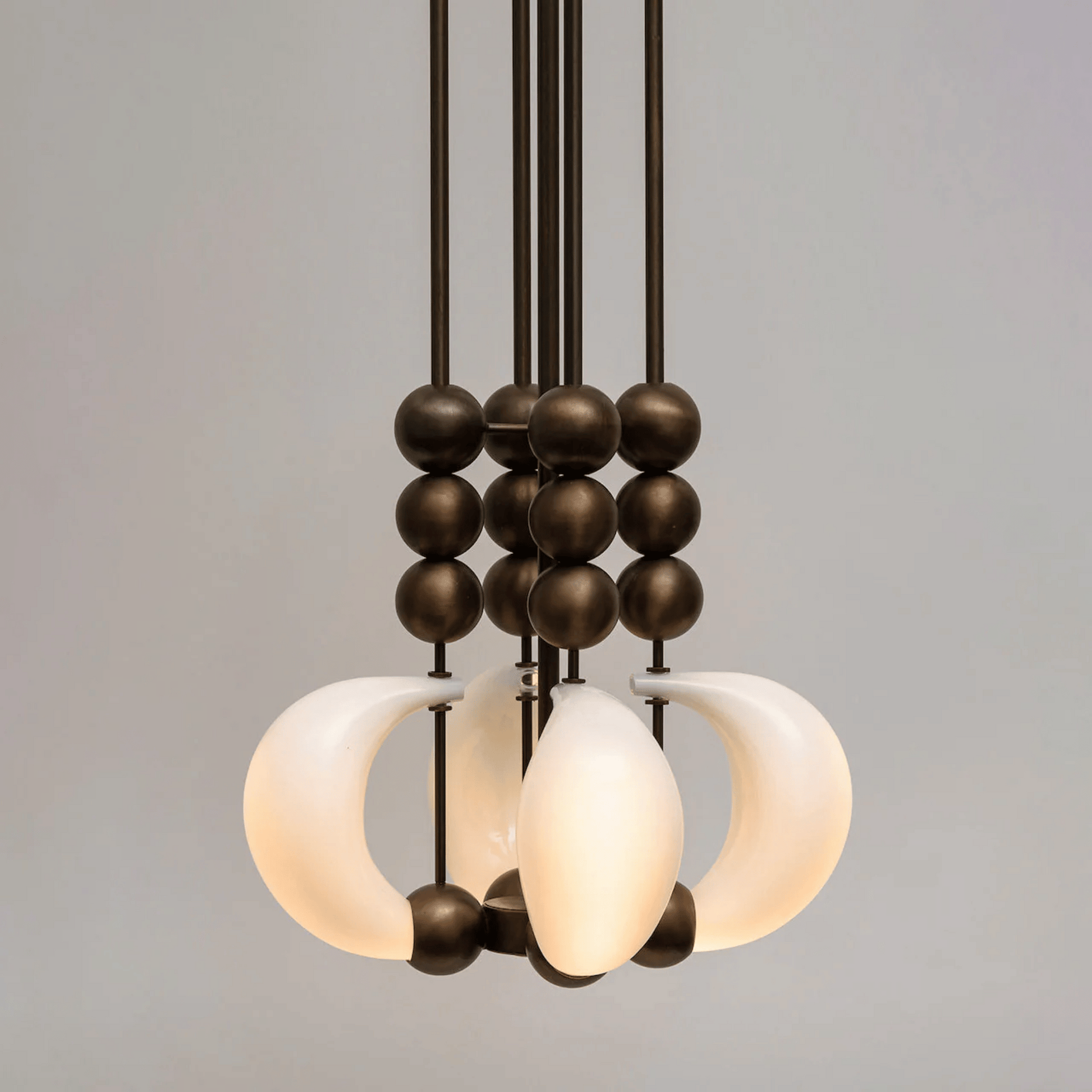 Modern chandelier with glass shades and metal accents on a gray background