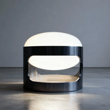 Modern table lamp with a black base and white shade on a gray surface.