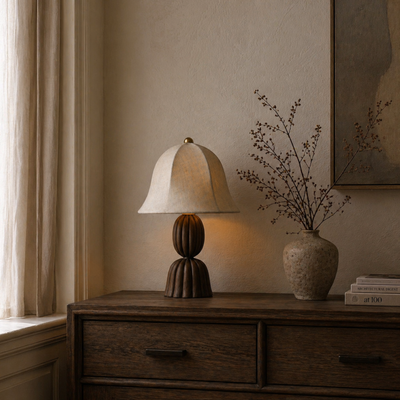Napoleon Chocolat table lamp on a wooden side table with a vase of dried flowers and books.