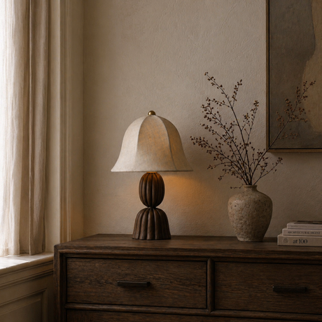 Napoleon Chocolat table lamp on a wooden side table with a vase of dried flowers and books.