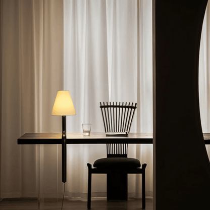 Modern black desk with chair and lamp against a curtain backdrop