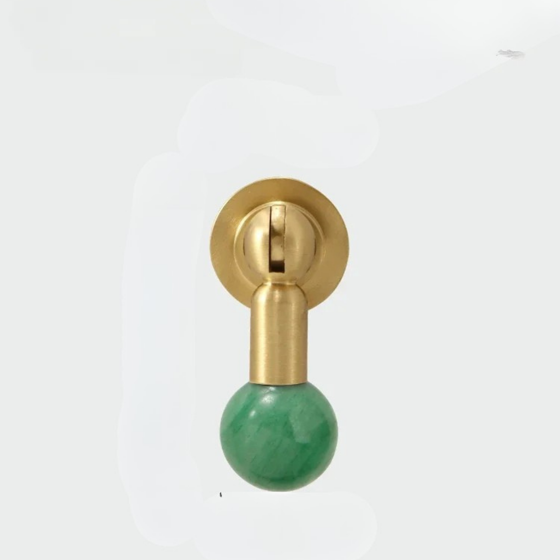 Brass cabinet knob with polished green gemstone sphere handle on white background.