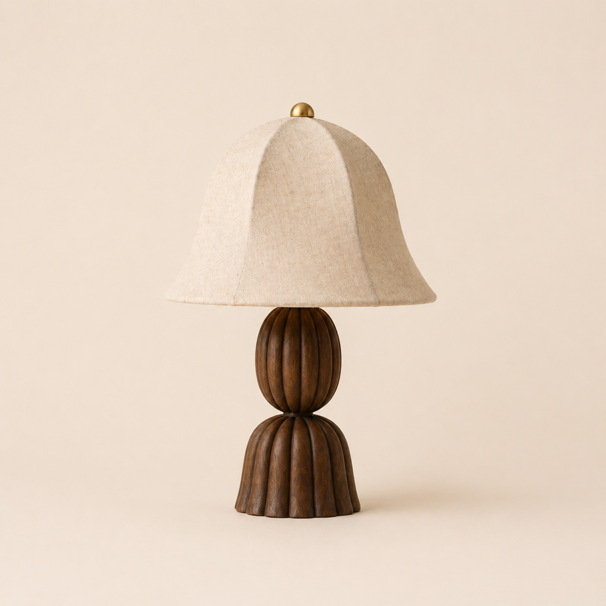 Table lamp with wooden base and beige fabric shade on a beige background