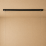 Black metal hanging shelf against a beige wall