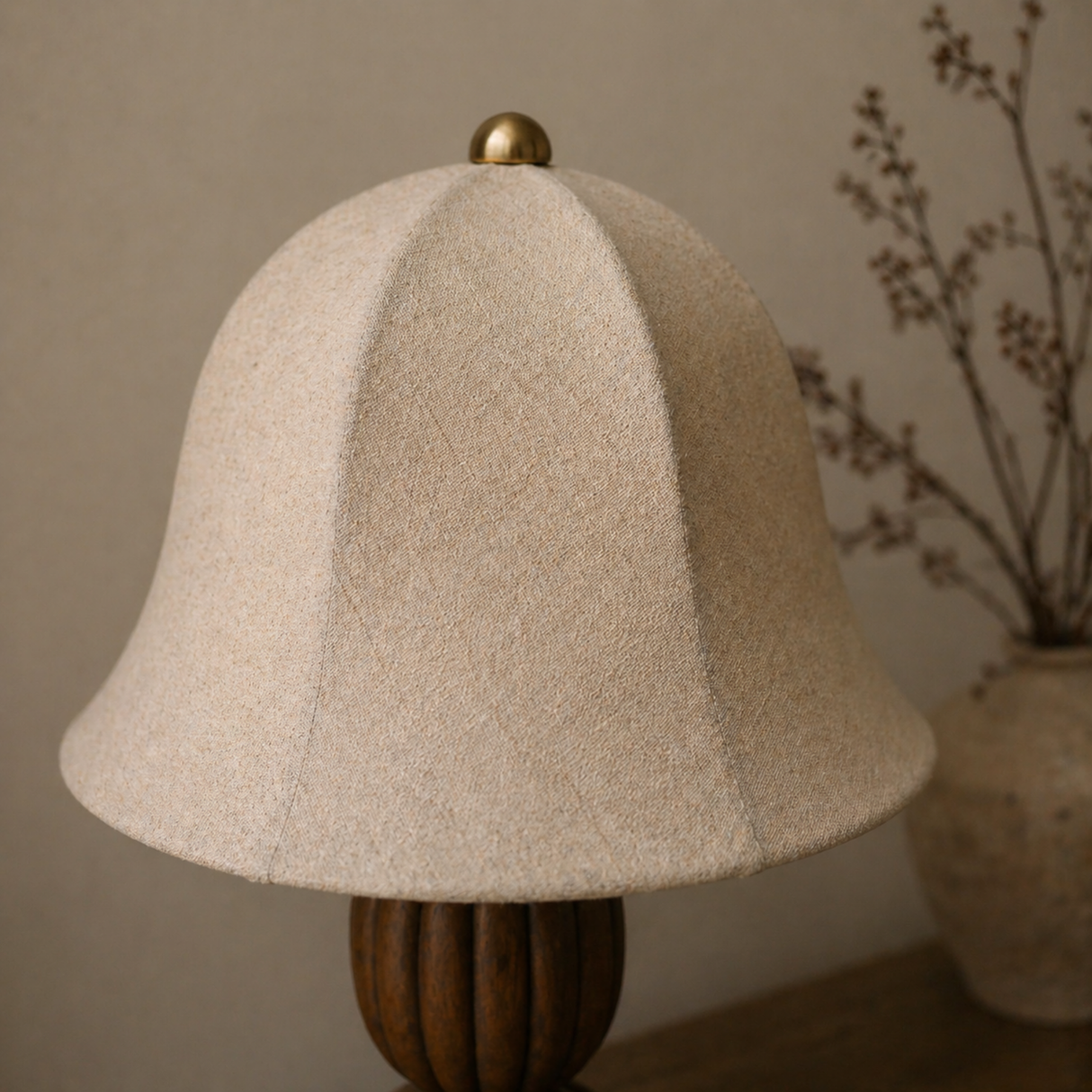 Textured lampshade with wooden base on a neutral background