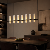 Modern chandelier in a dining room setting with a neutral color palette.
