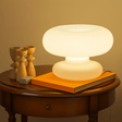 Table lamp on a wooden table with books and decorative items against a warm background