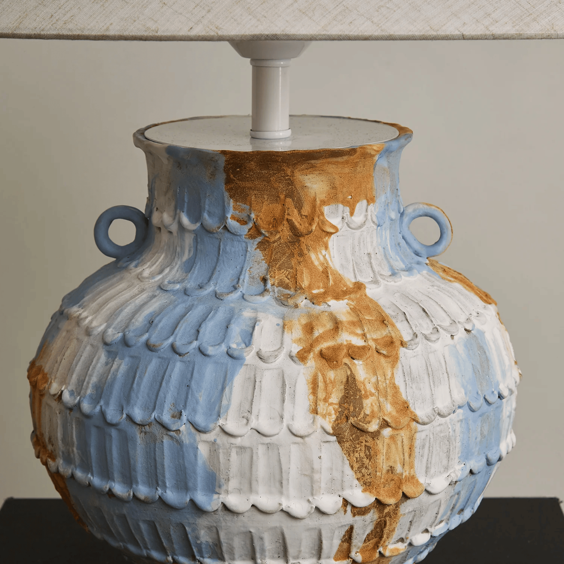 Decorative lamp with a textured blue, white, and brown design on a neutral background