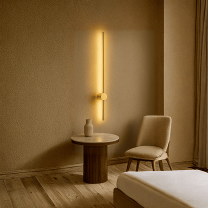 Modern interior with a wall-mounted light fixture, round table, and chair in a warm-toned room.