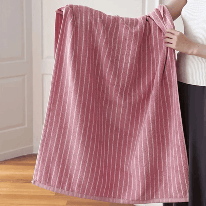 Person holding a red and white striped towel indoors.