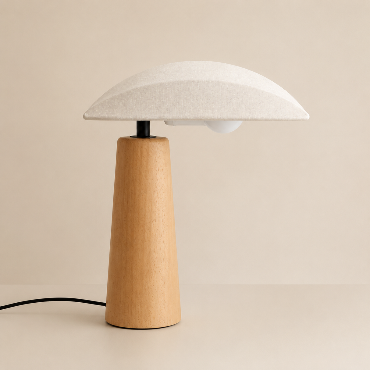 A modern mushroom-shaped table lamp with a light natural wood base and a white fabric-textured dome shade, set against a warm beige background.