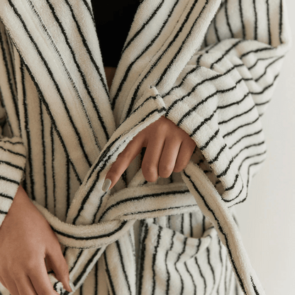 Close-up of a person wearing a black and white striped robe with a blurred background