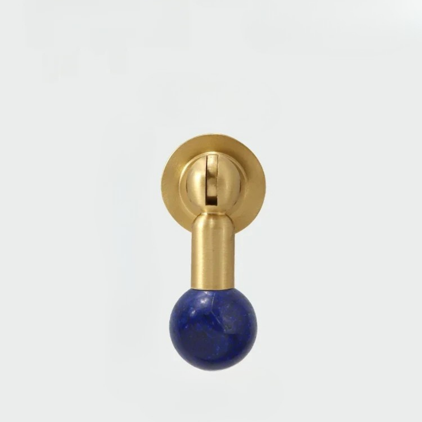 Modern brass knob featuring a deep blue gemstone sphere handle isolated on white background.