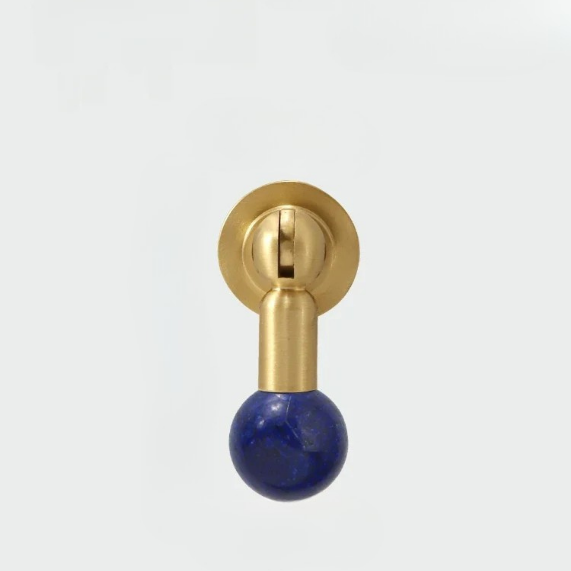 Modern brass knob featuring a deep blue gemstone sphere handle isolated on white background.