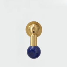 Modern brass knob featuring a deep blue gemstone sphere handle isolated on white background.