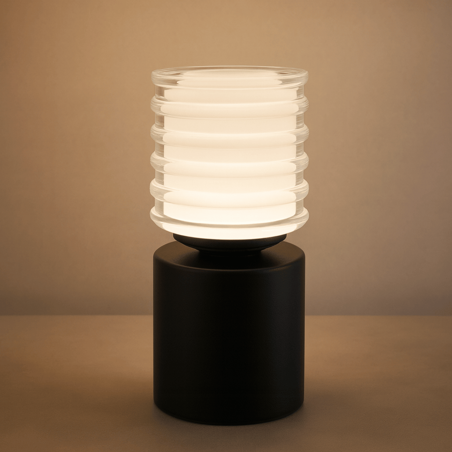 Table lamp with ribbed glass shade on a black base against a beige background