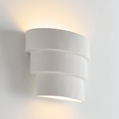 White cylindrical wall light fixture on a white background