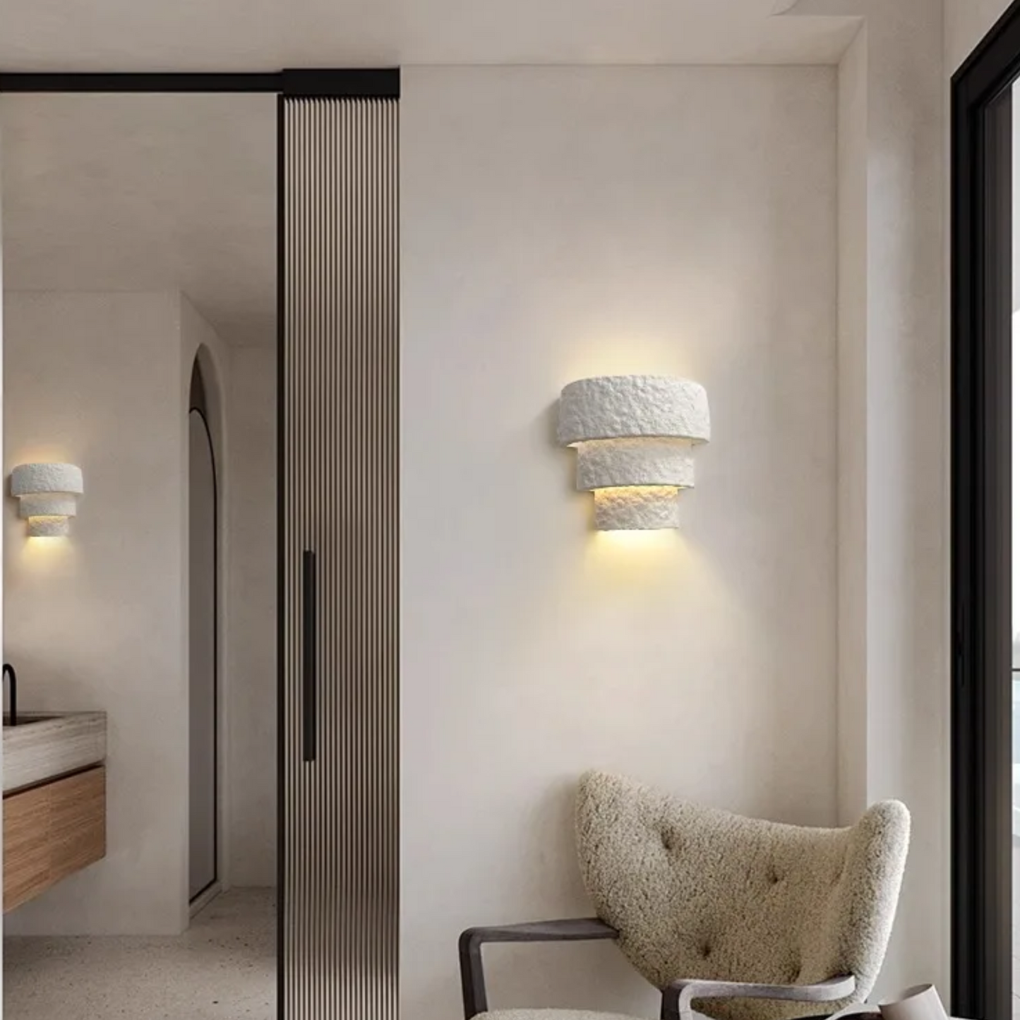 Modern interior design with textured wall sconces and a chair.