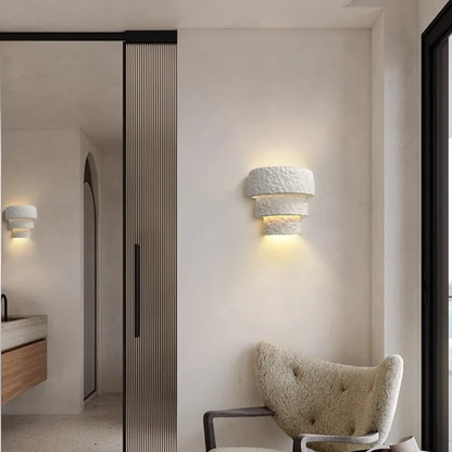 Modern interior design with textured wall sconces and a chair.