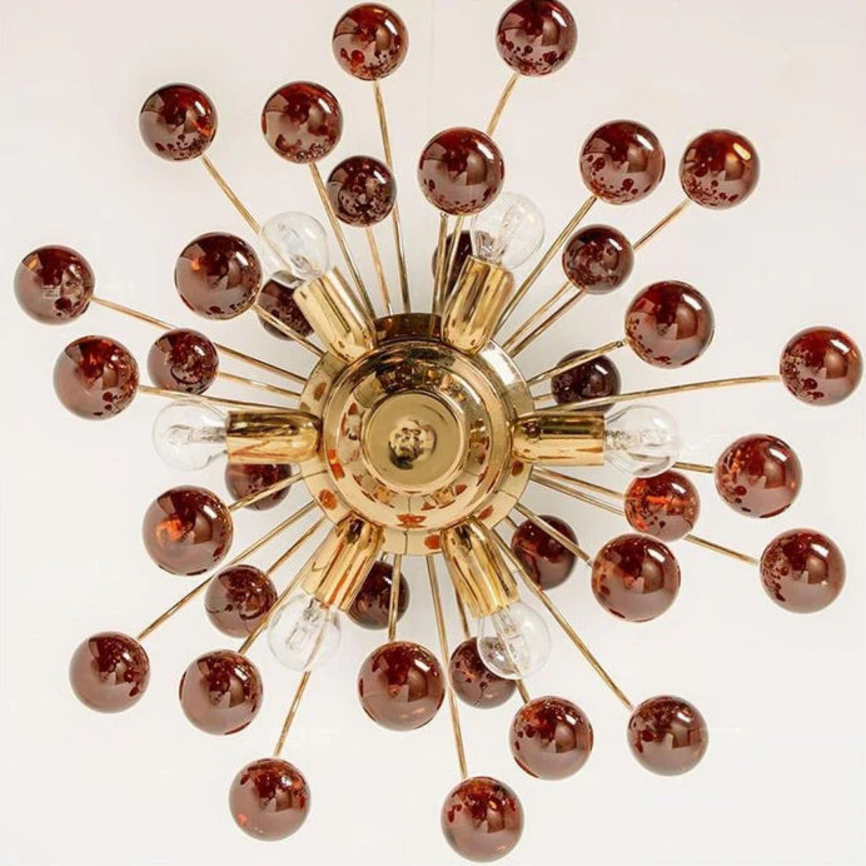 Decorative ceiling light fixture with gold center and brown spherical accents on a white background