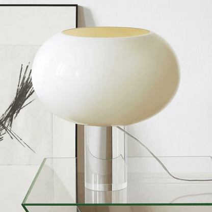 White table lamp with a gold interior on a glass surface