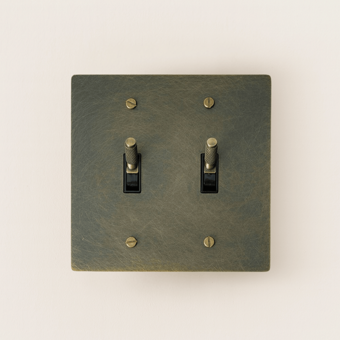 Bronze double switch plate with two toggle switches on a white background