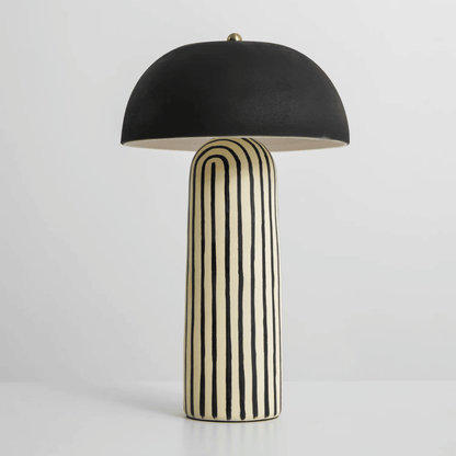 Table lamp with black umbrella shade and striped cylindrical base on a white background