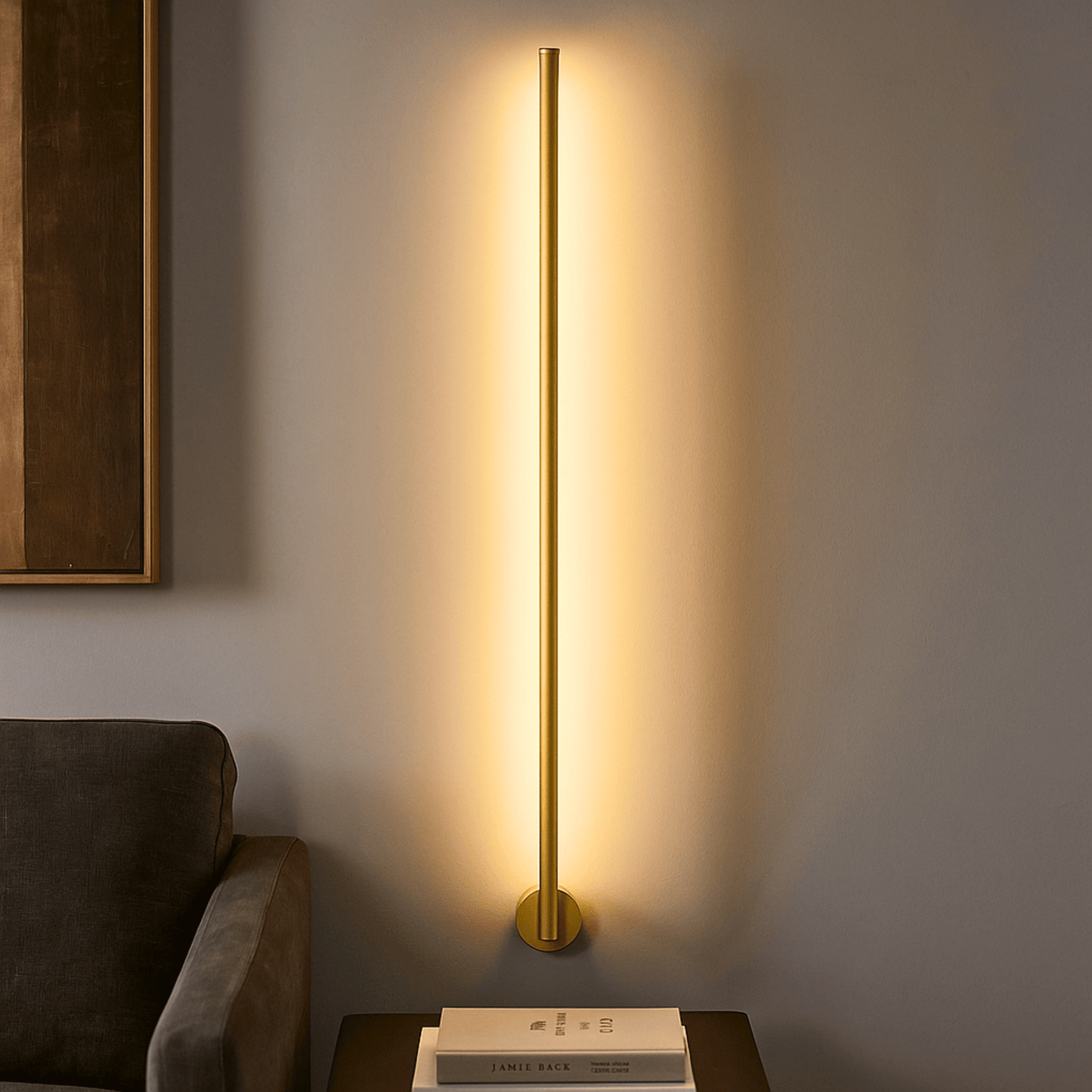 Gold floor lamp casting a warm glow on a wall next to a sofa.