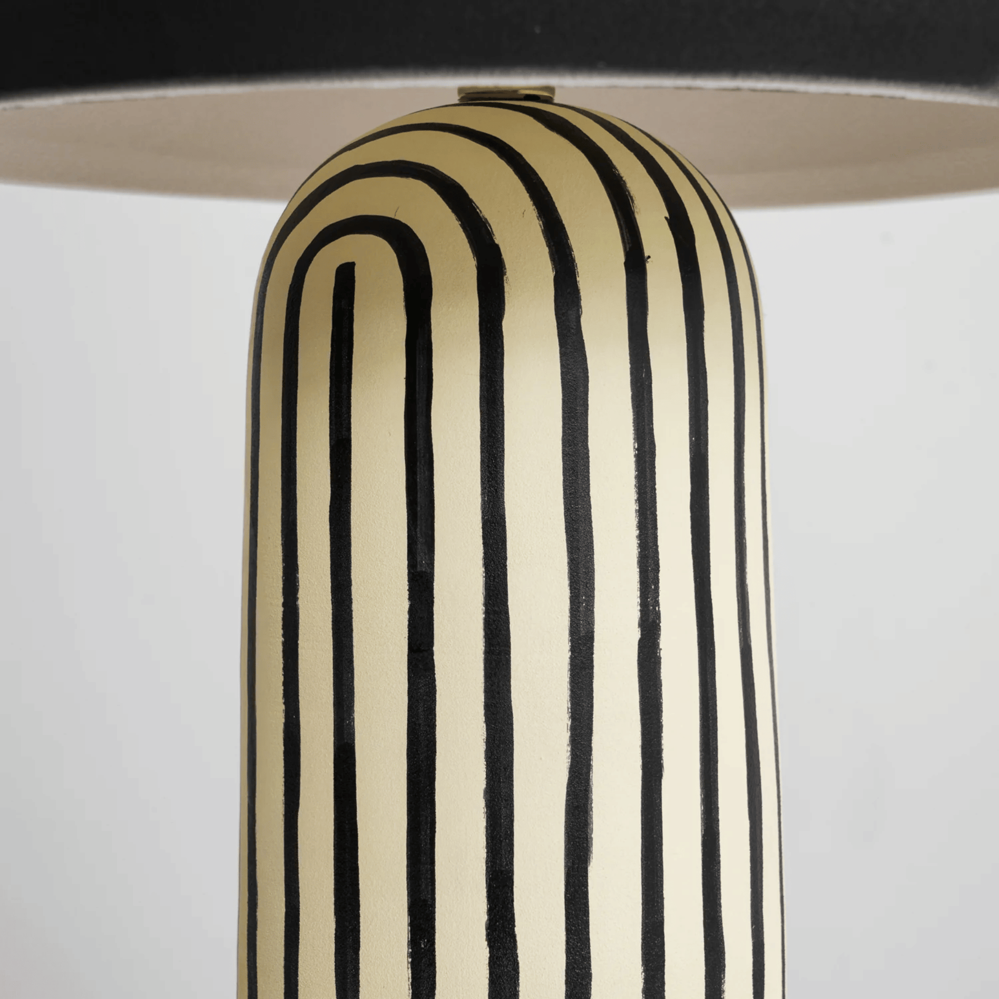 Decorative vase with black and beige vertical stripes on a white background