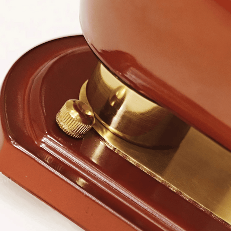 Close-up of a red and gold object, possibly a door handle or a decorative item.