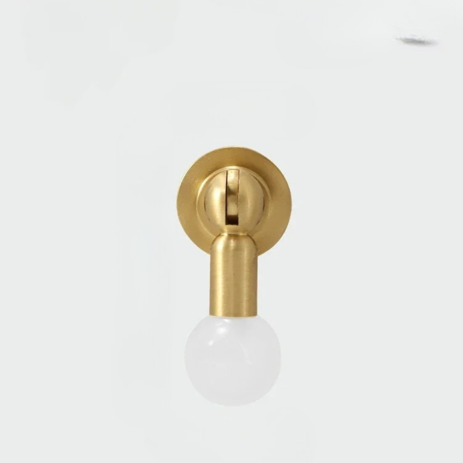 Minimal brass cabinet knob with a frosted white gemstone sphere handle on white background.