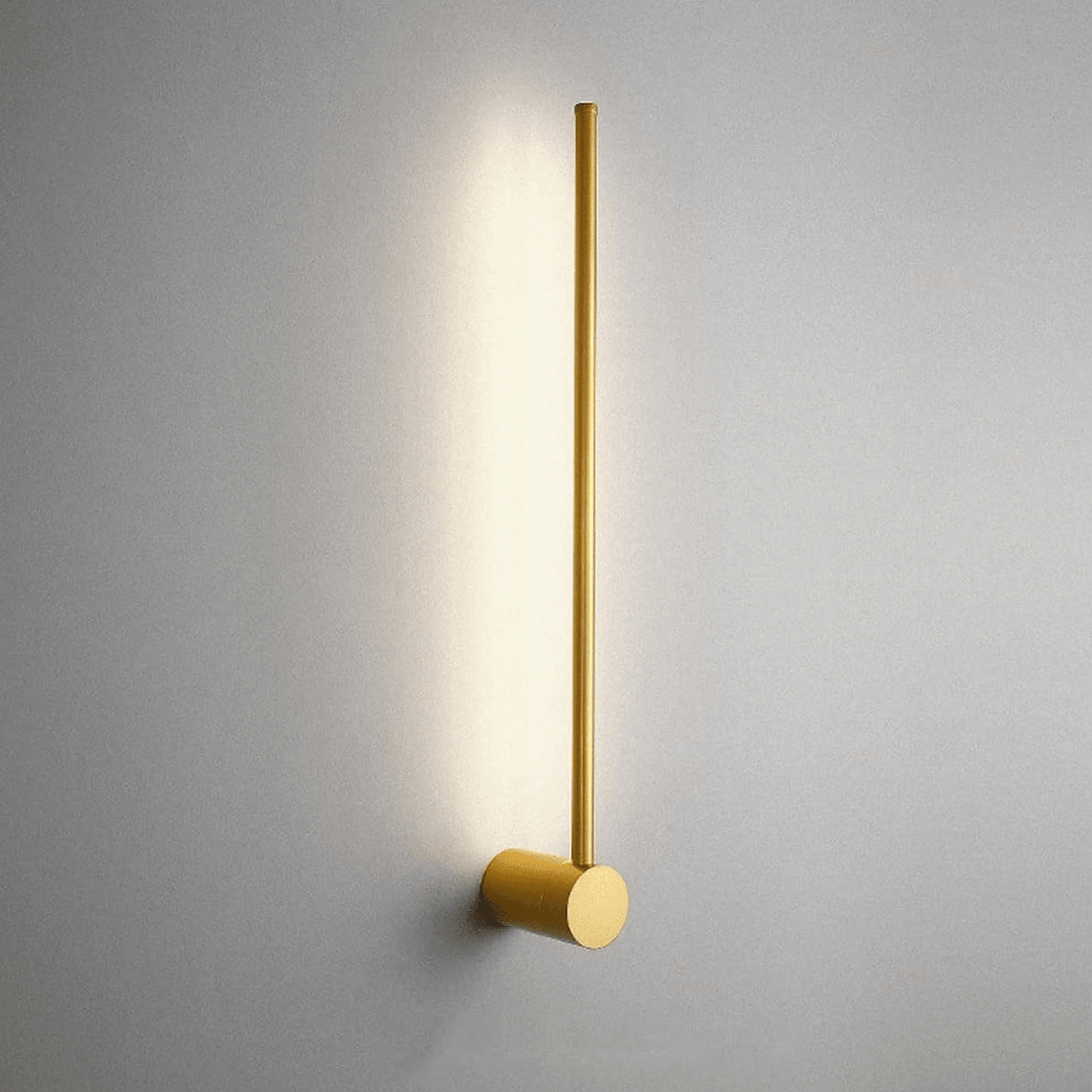 Gold wall-mounted light fixture on a gray wall