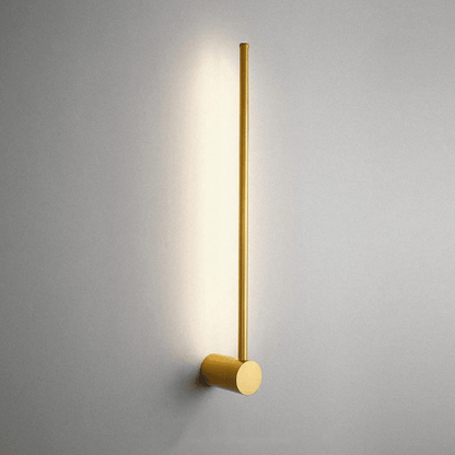 Gold wall-mounted light fixture on a gray wall
