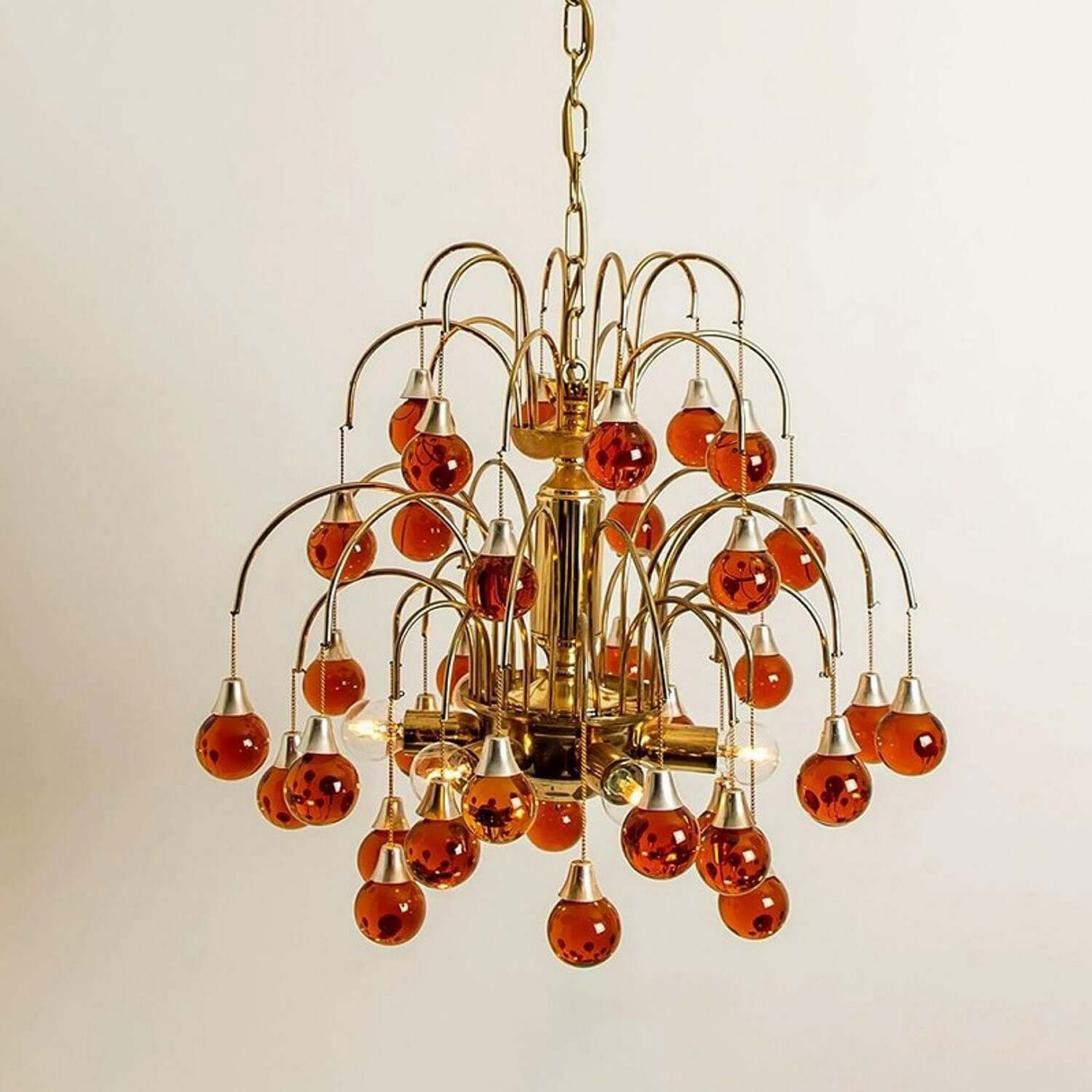 Chandelier with orange glass bulbs on a plain background