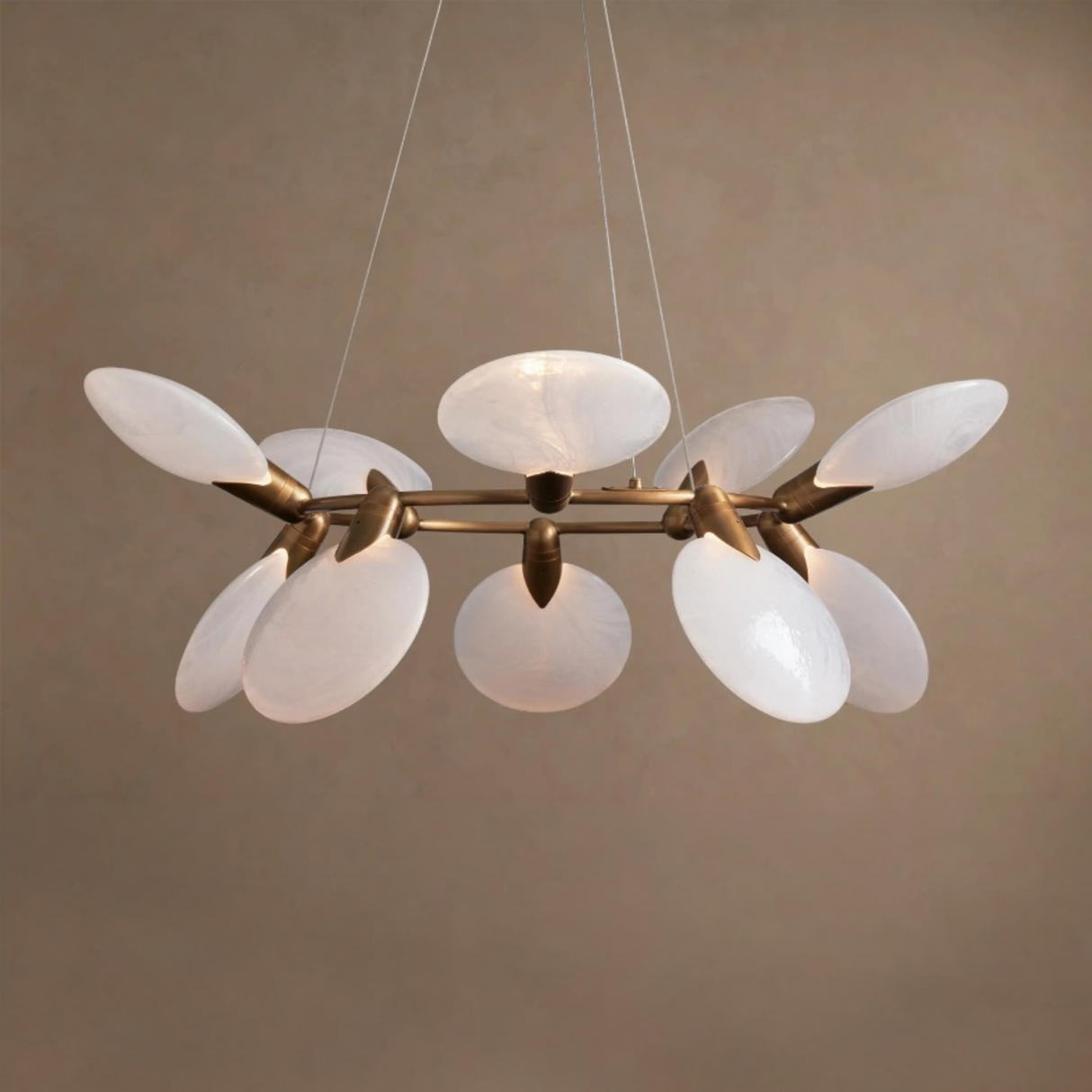 Modern chandelier with white glass shades and gold metal accents on a beige background