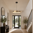 Modern interior with a chandelier, mirror, and plants in a well-lit room.