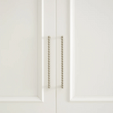 Close-up of a white cabinet door with decorative metal handle