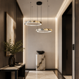 Modern hallway with pendant lights, decorative plant, and marble pedestal.