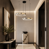 Modern hallway with pendant lights, decorative plant, and marble pedestal.